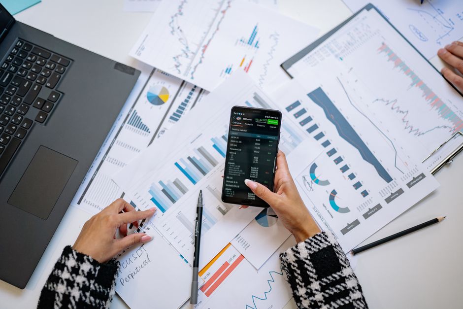 Uma visão de cima de gráficos e smartphone em um escritório, destacando a análise de dados.