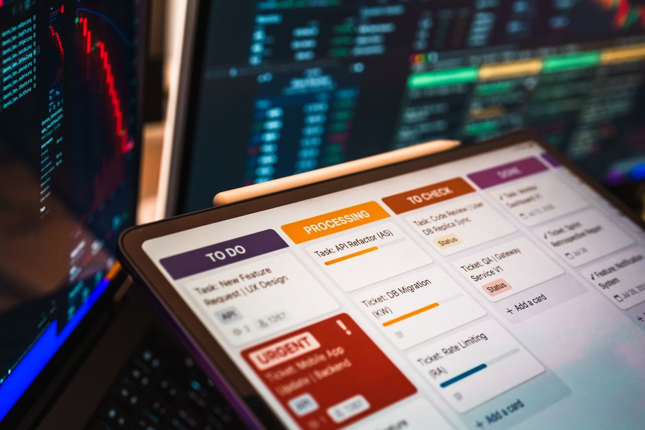 Quadro Kanban exibido na tela com gráficos e análise de dados em um ambiente de escritório moderno.