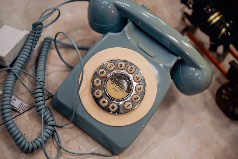 Telefone clássico azul com discagem rotativa, que exibe tecnologia nostálgica, ideal para designs com tema vintage.